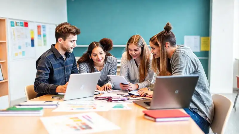 Estudiantes colaboran en aula moderna y vibrante