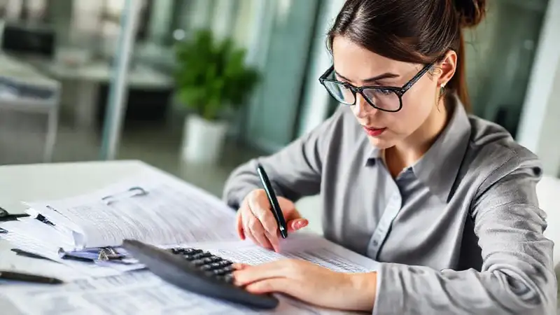 Contador profesional revisando documentos financieros en oficina