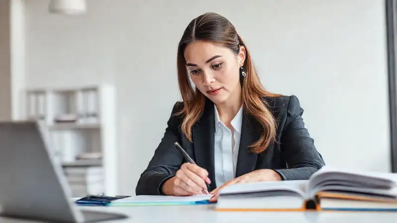 Mujer profesional escribiendo en oficina moderna