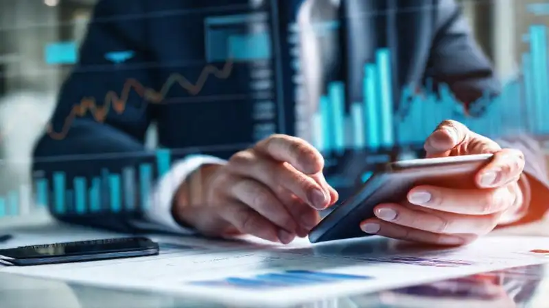 Analista revisa gráficos financieros en oficina moderna