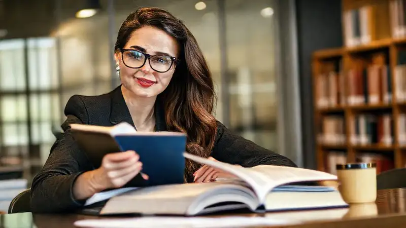 Joven mujer estudia derecho en biblioteca moderna