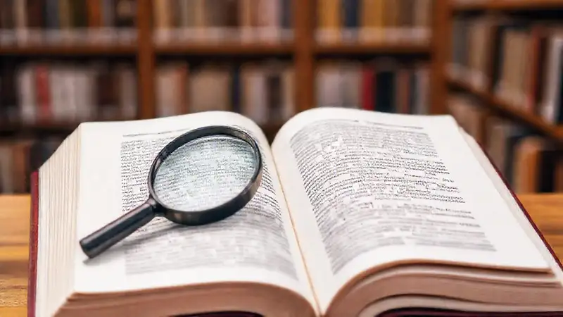 Libro abierto con artículos y resaltados académicos