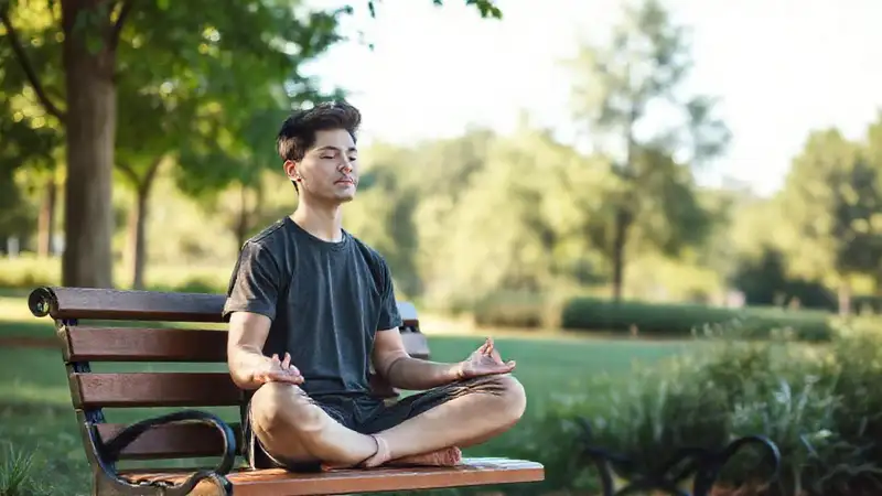 Estudiante meditando en parque tranquilo y brillante