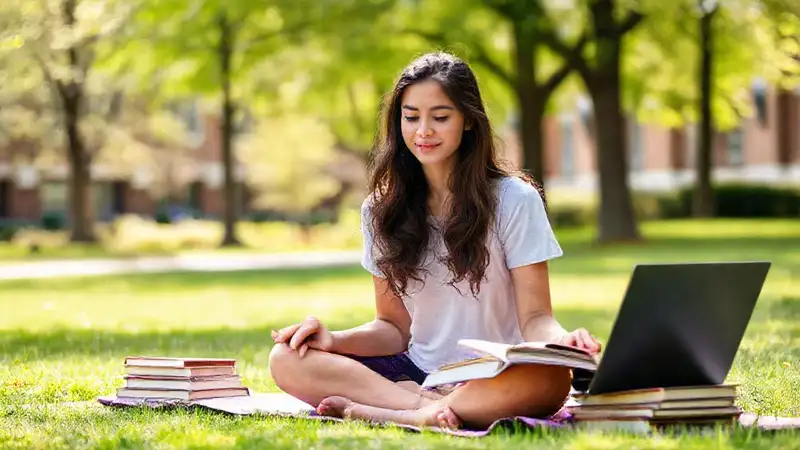 Estudiante tranquilo estudiando en campus exterior